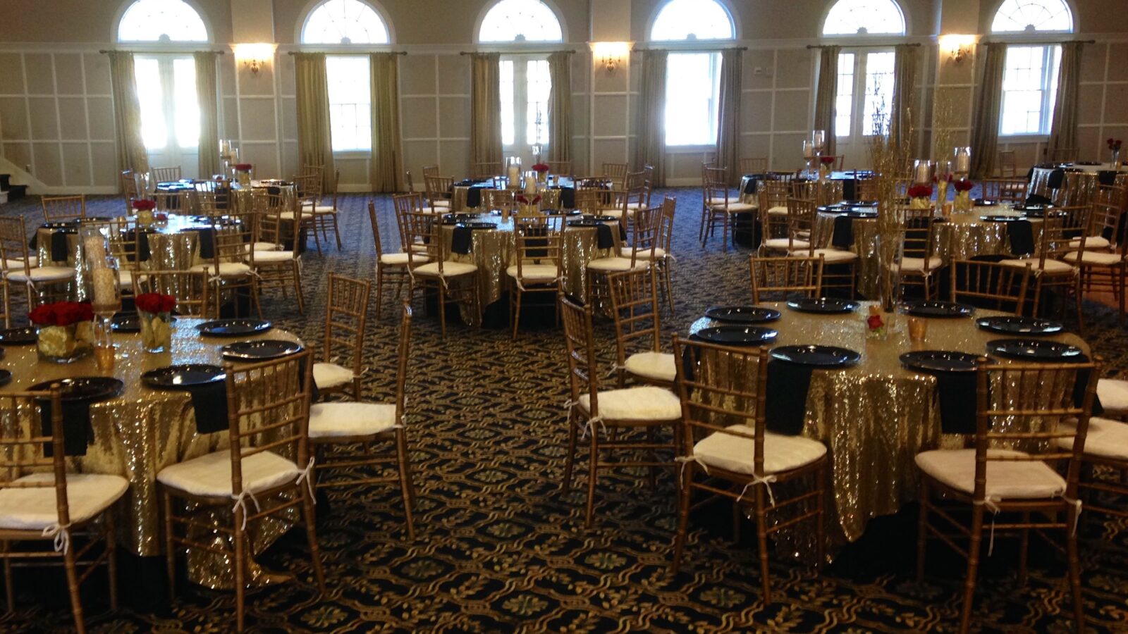 Gold Chiavari chairs with sequin linens in a historic ballroom